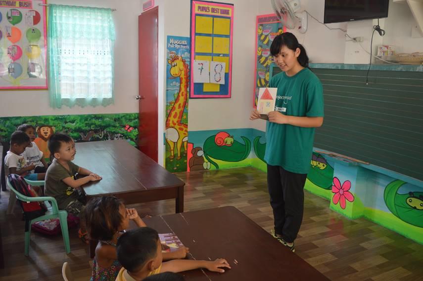 A Projects Abroad Childcare volunteer teaches a kindergarten class in the Philippines. A group of children listen to a class taught by a Childcare volunteer working at a kindergarten in the Philippines.